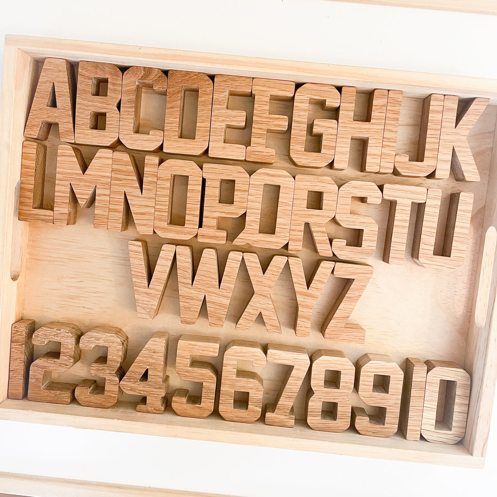 Wooden Oak handmade alphabet and numbers toy arranged in a wooden tray in order.