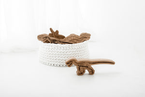 White handmade storage basket. Made with recycled t-shirt yarn. Contains wooden toy dinosaurs. Perfect to store household items.