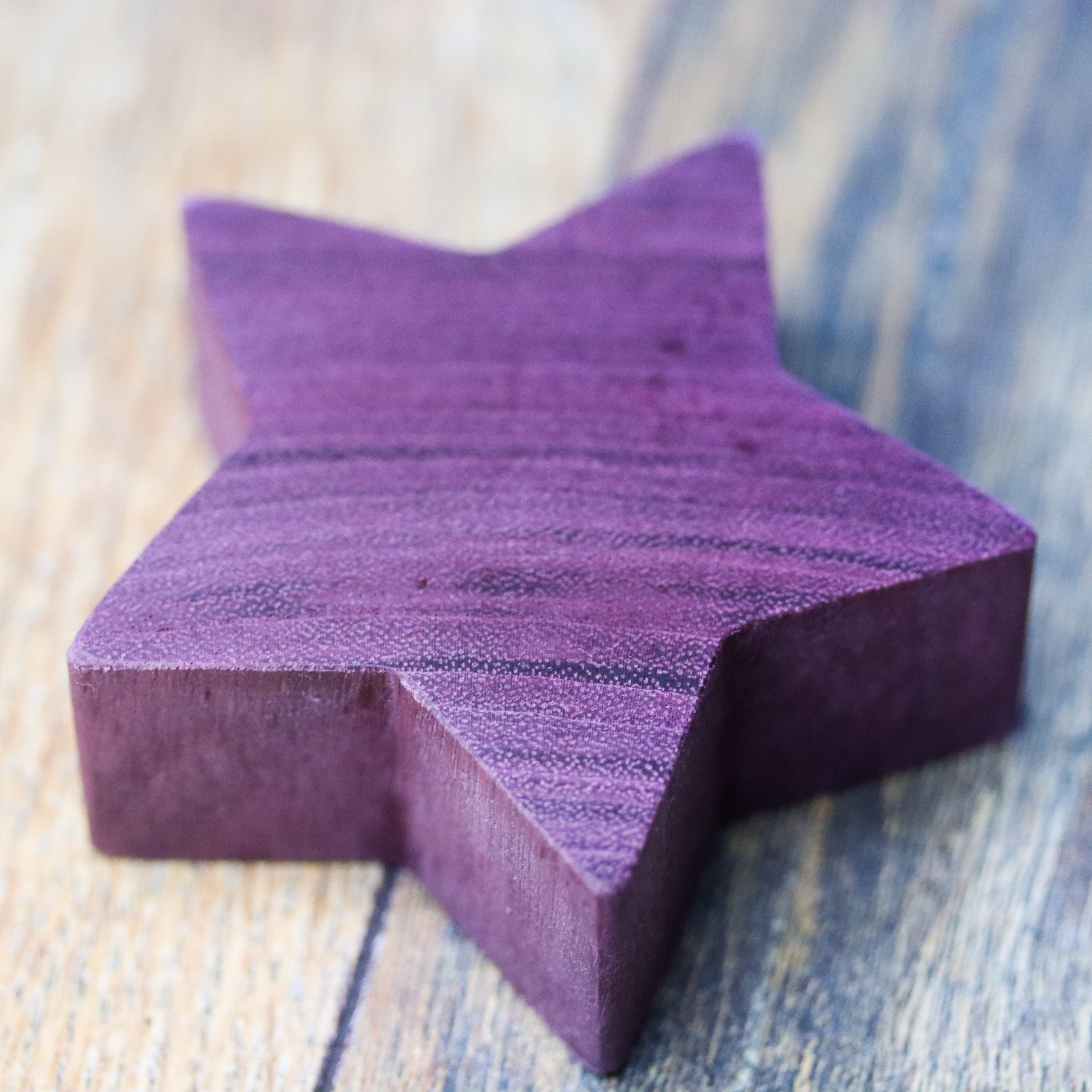 Close up. Wooden purpleheart star decor item on a wooden background