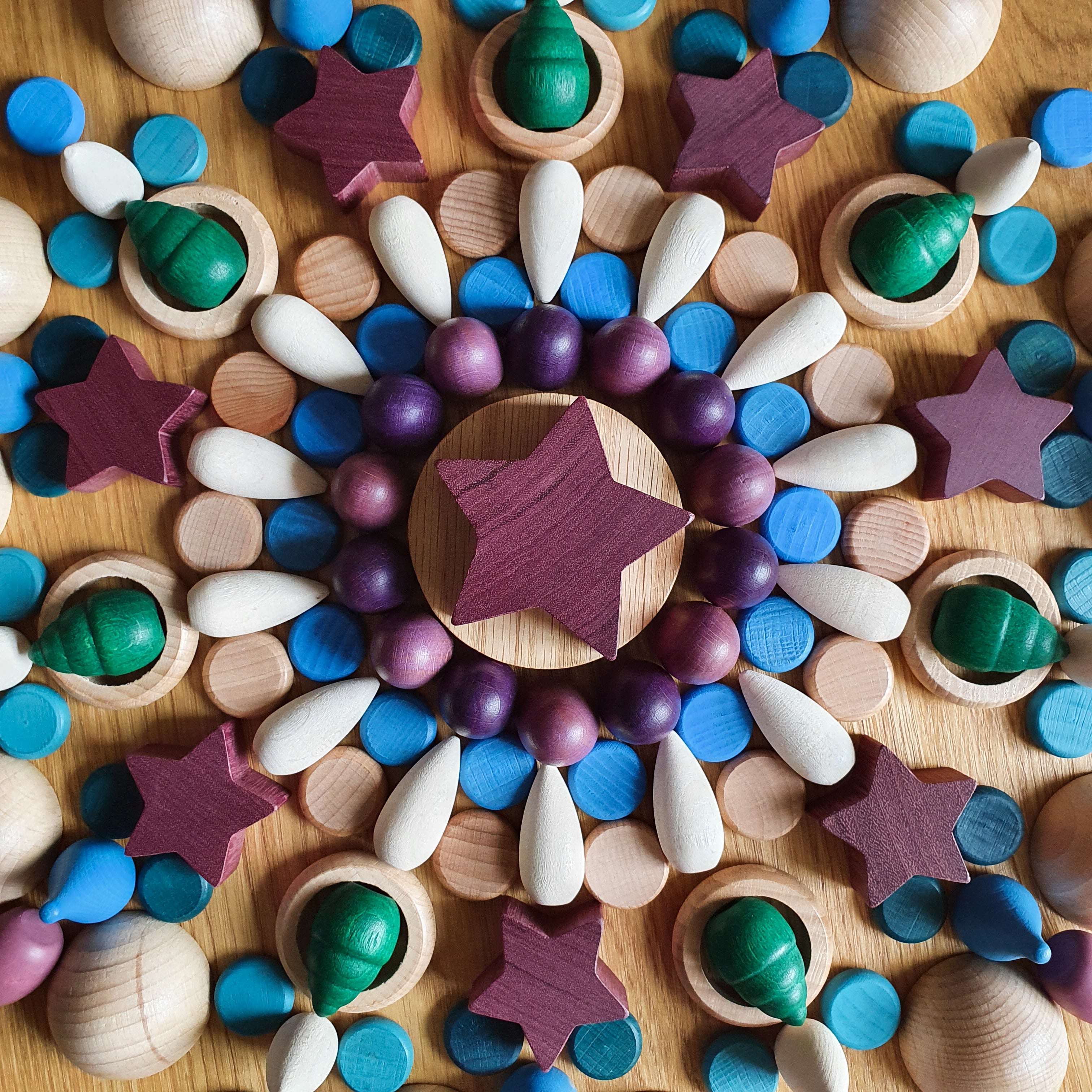 Wooden purpleheart star mandala using smaller wooden purpleheart stars and other small wooden toys.